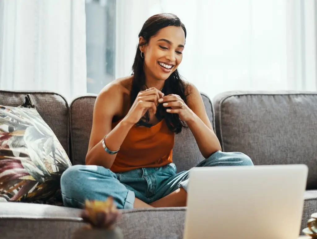 Shot of a young woman using a laptop on the sofa at home